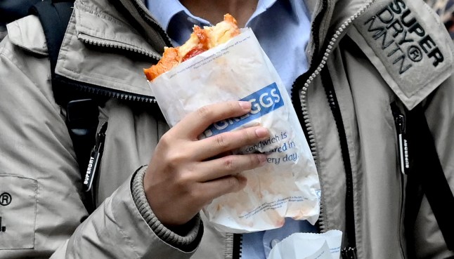 A customer carries take-away purchase after leaving a Greggs bakery in central London on March 5, 2024. British bakery Greggs, famed for its sausage rolls, said Tuesday it logged soaring profit last year, as consumers flocked to the budget chain during a cost-of-living crisis. Net profit leapt almost a fifth to ??142.5 million ($180.6 million) from 2022, Greggs said in a results statement, adding that revenue soared by a similar proportion to ??1.8 billion. (Photo by JUSTIN TALLIS / AFP) (Photo by JUSTIN TALLIS/AFP via Getty Images)