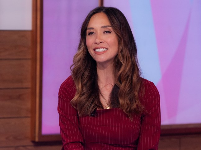 Myleene Klass smiling and wearing a burgundy top