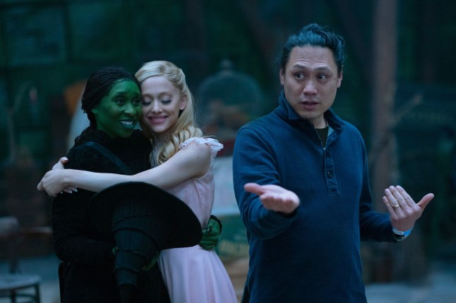 This image released by Universal Pictures shows Cynthia Erivo, left, and Ariana Grande, with director Jon M. Chu, right, on the set of the film "Wicked." (Universal Pictures via AP)