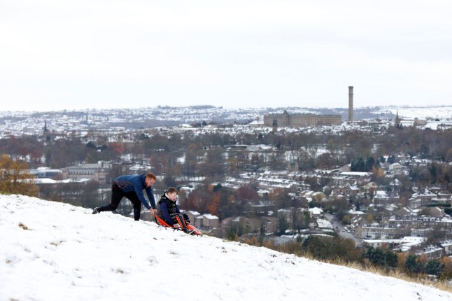 BRADFORD - NOVEMBER 19: People play with a sledge on a hill overlooking the City of Bradford on November 19, 2024 in Bradford, United Kingdom. The Met Office has issued warnings for snow and ice across parts of Northern Ireland, Scotland, Northern England, and the Midlands, as a low pressure system from the Atlantic brings freezing temperatures. (Photo by George Wood/Getty Images)