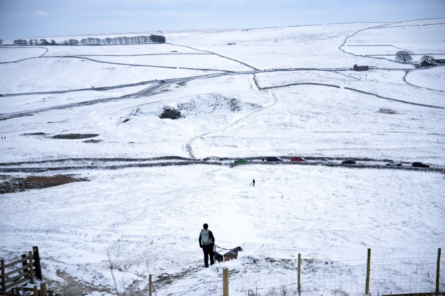 CASTLETON, UNITED KINGDOM - NOVEMBER 19: A walker looks out over the Peak District after overnight snowfall on November 19, 2024 in Castleton, United Kingdom. The Met Office has issued warnings for snow and ice across parts of Northern Ireland, Scotland, Northern England, and the Midlands, as a low pressure system from the Atlantic brings freezing temperatures. (Photo by Christopher Furlong/Getty Images)