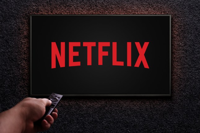 Man turns on TV with remote control. Netflix logo on TV screen. Netflix streaming service for watching films and TV shows