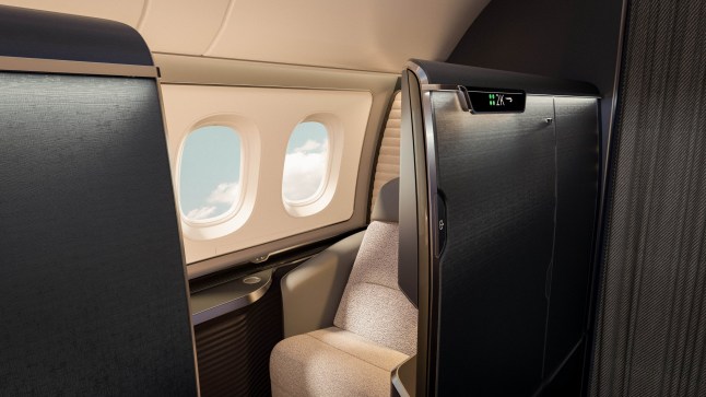 The interior of a British Airways first class cabin with a window seat