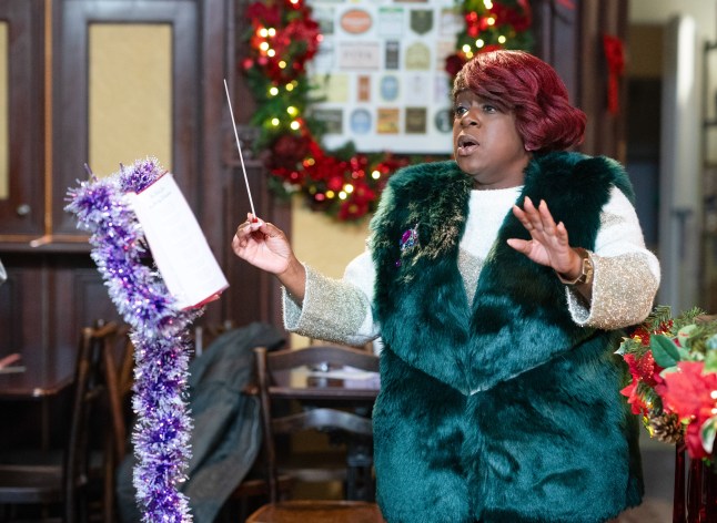 Kim conducting the Christmas choir in EastEnders