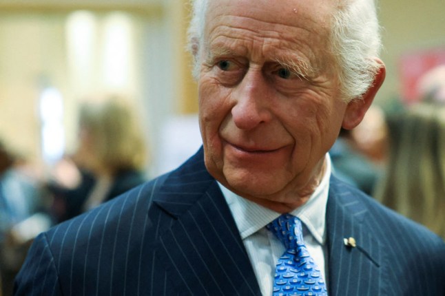 Britain's King Charles III reacts as he meets Disasters Emergency Committee (DEC) staff, aid workers and volunteers at St Peter's Church, in London