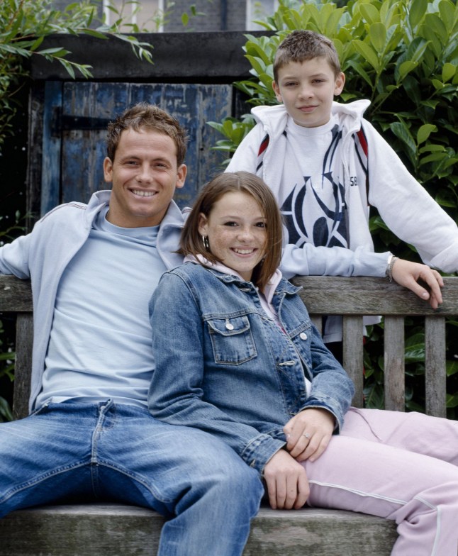 Mickey, Demi and Darren Miller sat on a bench in Albert Square in EastEnders