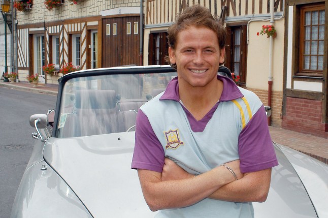 EastEnders' Joe Swash poses on the bonnet of a car, in the 2000s