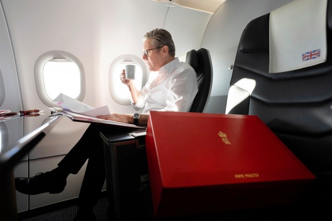 Britain's Prime Minister Keir Starmer works on the plane as he flies to Washington DC, for talks with President Joe Biden on resolving the conflicts in Ukraine and Gaza, Thursday, Sept. 12, 2024. (Stefan Rousseau/Pool Photo via AP)