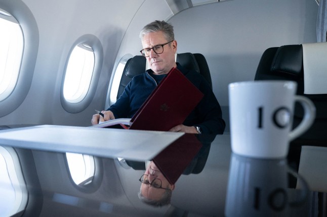 Britain's Prime Minister Keir Starmer poses for a photograph as he works whilst travelling on a Government aeroplane on November 17, 2024, en route to attend the G20 summit in Rio de Janeiro, Brazil. The G20 Leaders' Summit will take place in Rio de Janeiro between November 18 and 19, 2024. (Photo by Stefan Rousseau / POOL / AFP) (Photo by STEFAN ROUSSEAU/POOL/AFP via Getty Images)