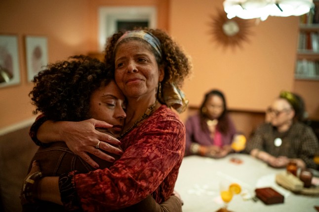 two women hug in living room in picture from Missing You