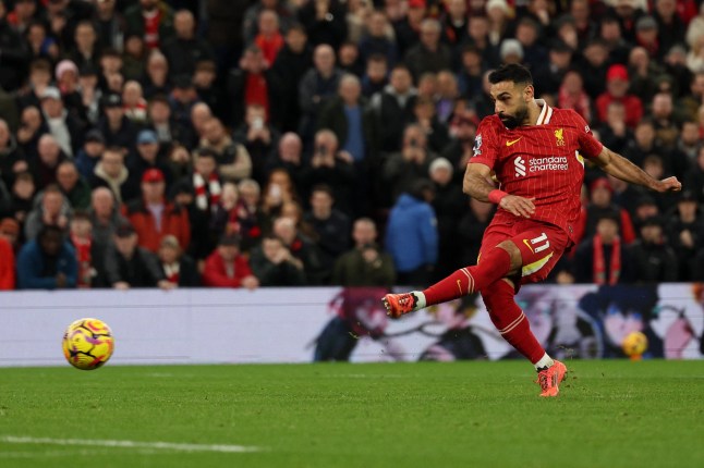 Liverpool's Egyptian striker #11 Mohamed Salah shoots from the penalty spot to score the team's second goal during the English Premier League football match between Liverpool and Manchester City at Anfield in Liverpool, north west England on December 1, 2024. (Photo by Adrian Dennis / AFP) / RESTRICTED TO EDITORIAL USE. No use with unauthorized audio, video, data, fixture lists, club/league logos or 'live' services. Online in-match use limited to 120 images. An additional 40 images may be used in extra time. No video emulation. Social media in-match use limited to 120 images. An additional 40 images may be used in extra time. No use in betting publications, games or single club/league/player publications. / (Photo by ADRIAN DENNIS/AFP via Getty Images)