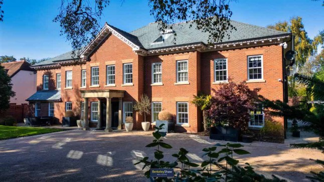 The exterior of Jurgen Klopp's former home just north of Liverpool in Merseyside. It is a large red brick home with a grey roof and columns around the door