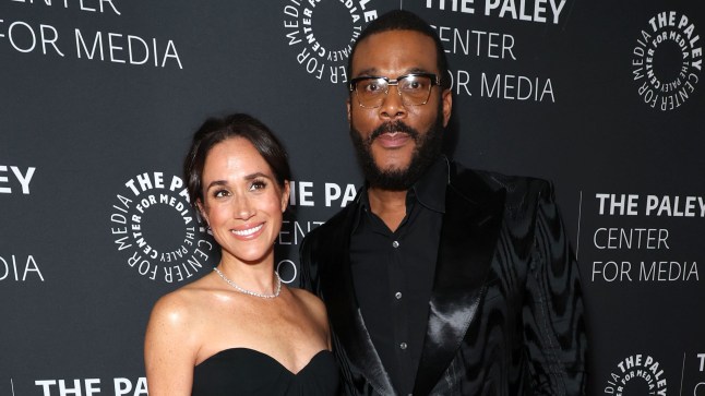 Meghan Markle and Tyler Perry smile together on the red carpet, both in black outfits