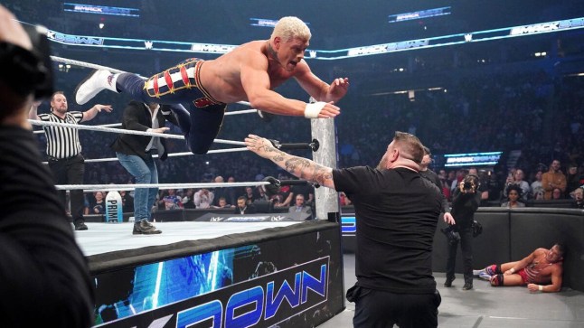 WWE Champion Cody Rhodes dives out of the ring onto Kevin Owens during SmackDown