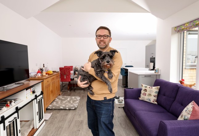 Richard Tosh with his dog liquorice at his home in St Neots Cambridgeshire. Richard and his family have recently bought the four bedroom property after returning to the UK from New Zealand.