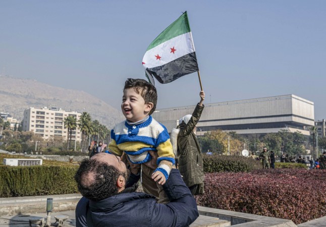 DAMASCUS, SYRIA - DECEMBER 9: Syrians gather at Umayyad Square to celebrate the collapse of 61 years of Baath Party rule in Damascus, Syria on December 9, 2024. Sixty-one years of Baath Party rule in Syria collapsed on Sunday when, the capital fell out of the hands of regime control. (Photo by Murat Sengul/Anadolu via Getty Images)