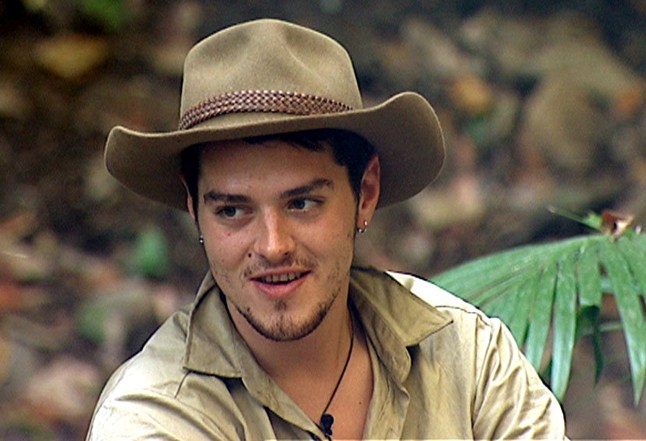 Matt Willis in hat as he sits in jungle in i'm a celeb