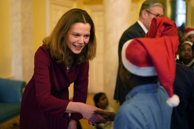 LONDON, ENGLAND - DECEMBER 13: Victoria Starmer wife of the Britain's Prime Minister Keir Starmer, shakes hands with a guest as they host a children's Christmas party inside 10 Downing Street on December 13, 2024 in London, England. (Photo by Alberto Pezzali - WPA Pool/Getty Images)