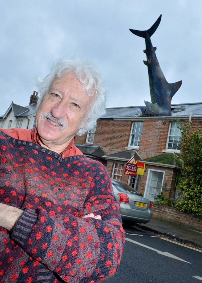 FILE PICTURE - Bill Heine outside his house number two New High Street in Oxford. Photo released December 16 2024. The owner of the iconic "shark house" in Oxford says "come while you can" after council demand closure of quirky Airbnb.Oxford City Council won the planning appeal banning the use of short let accommodation last week for the quirky property in New Street, Headington, more widely known as the Shark House - which features a 25ft shark sticking out of its roof.This comes after owner Dr. Magnus Hanson-Heine, whose father Bill Heine constructed the sculpture without official planning permission from Oxford City Council in 1986.For the last five years, Dr. Hanson-Heine has been letting the property out on Airbnb for short term stays - but received notice from the council to shut it down, after a member of the public complained about the change from a residential use to a short-term let.