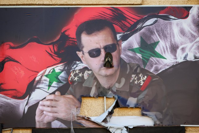 DAMASCUS, SYRIA - DECEMBER 15: A sandal has been inserted into a poster of the toppled former Syrian President Bashar al-Assad at the Mezzeh Military Airport on December 15, 2024 in Damascus, Syria. Israel says it is destroying Syria's military capabilities to prevent any threat from the Islamist forces of Hayat Tahrir al-Sham (HTS), though the HTS leader over the weekend warned Israel to stop such attacks. The fall of the Assad regime marks a new chapter for Syria, which has been mired in a multi-party civil war since 2011, sparked by the Arab Spring uprisings. (Photo by Scott Peterson/Getty Images)