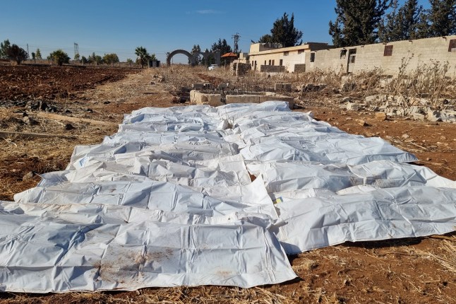 Body bags lie on a field after a mass grave was discovered in an agricultural land in Izra, in Syria's southern Daraa province, on December 16, 2024. Islamist-led rebels took Damascus in a lightning offensive on December 8, ousting president Bashar al-Assad and ending five decades of Baath rule in Syria. According to the Syrian Observatory for Human Rights, more than 100,000 people died in Syria's jails and detention centres from 2011. (Photo by Sam HARIRI / AFP) (Photo by SAM HARIRI/AFP via Getty Images)