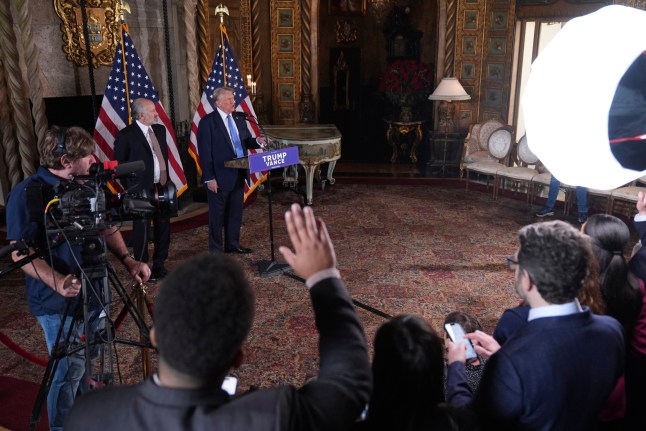 President-elect Donald Trump speaks during a news conference at Mar-a-Lago, Monday, Dec. 16, 2024, in Palm Beach, Fla., as Commerce Secretary nominee Howard Lutnick listens. (AP Photo/Evan Vucci)