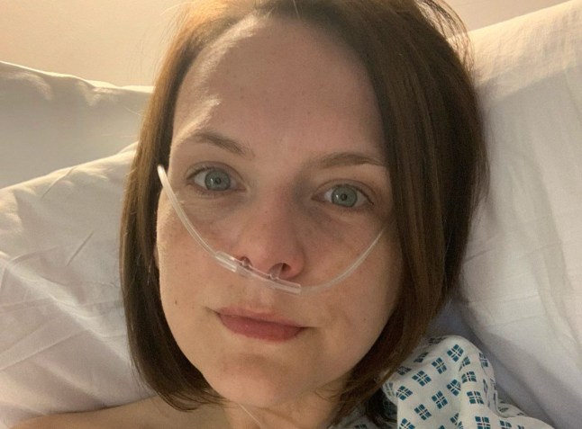 Amy Roberts (head only) lying in a hospital bed with tubes going into her nose (Picture: Amy Roberts)