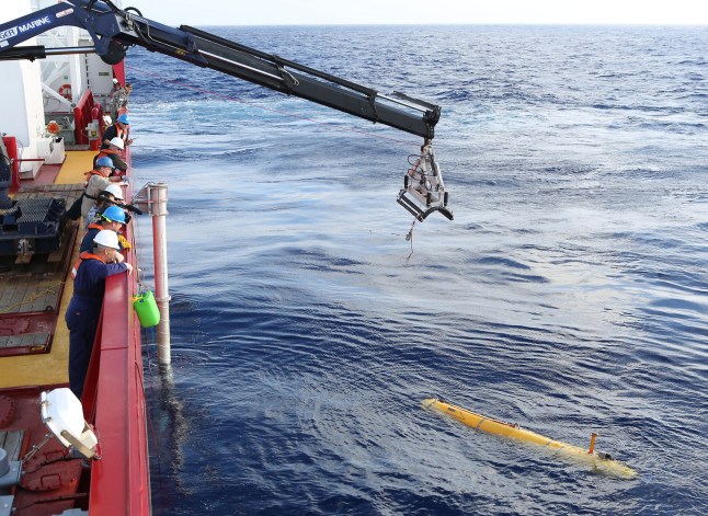 AT SEA - APRIL 14: In this handout image provided by Commonwealth of Australia, Department of Defence, Phoenix Autonomous Underwater Vehicle (AUV) Bluefin-21 is craned over the side of Australian Defence Vessel Ocean Shield in the search for missing Malaysia Airlines flight MH 370 on April 14, 2014. Twenty-six nations have been involved in the search for Malaysia Airlines Flight MH370 since it disappeared more than a month ago. (Photo by LEUT Kelli Lunt/Australia Department of Defence via Getty Images)