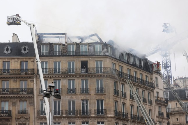 Firefighters work after a fire broke out on the top floor of a residential and office building near the busy St. Lazare train station in northwest Paris, Tuesday, Dec. 24, 2024. (AP Photo/Thomas Padilla)