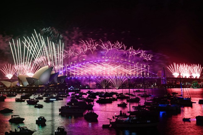 Fireworks light up the midnight sky over Sydney Harbour Bridge and Sydney Opera House during 2025 New Year's Day celebrations in Sydney on January 1, 2025. (Photo by Saeed KHAN / AFP) (Photo by SAEED KHAN/AFP via Getty Images)