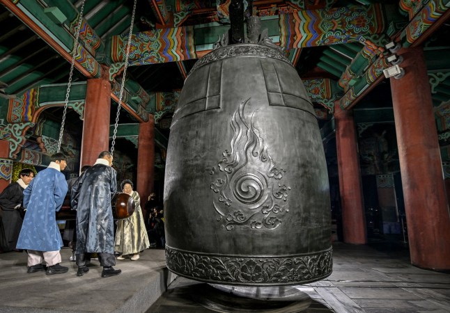 Participants hit a huge bell to welcome the 2025 New Year's Day, during celebrations post midnight at the Bosingak pavilion in central Seoul on January 1, 2025. (Photo by Jung Yeon-je / AFP) (Photo by JUNG YEON-JE/AFP via Getty Images)