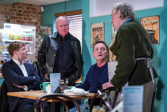 Phil approaches Nigel, Billy and Jay in the cafe in EastEnders