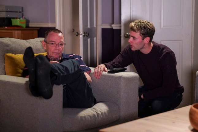 Peter talks to Ian, who is slumped over an armchair in EastEnders