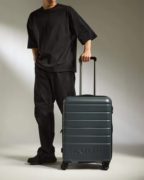 Image of model posing with Medium Suitcase from Antler in dark green