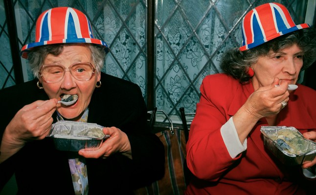 Patriotic British Women eating Jellied Eels celebrating Victory for Europe (VE day) in east London England UK