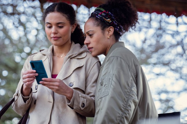 Missing You. (L to R) Jessica Plummer as Stacey, Rosalind Elezar as Kat Donovan in Missing You looking at a phone