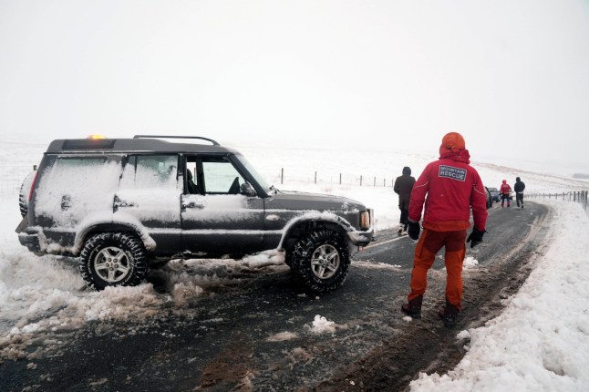 A member of a Mountain Rescue team after helping to clear cars from a snow drift near Ribblehead, in North Yorkshire. Large parts of the UK are facing heavy snow and freezing rain, which is likely to cause disruption, after two amber weather warnings came into force. Stranded vehicles on the roads, delayed or cancelled rail and air travel, and power cuts are all likely as the country grapples with a week-long spell of wintry conditions, the Met Office said. Picture date: Monday January 6, 2025. PA Photo. Photo credit should read: Danny Lawson/PA Wire