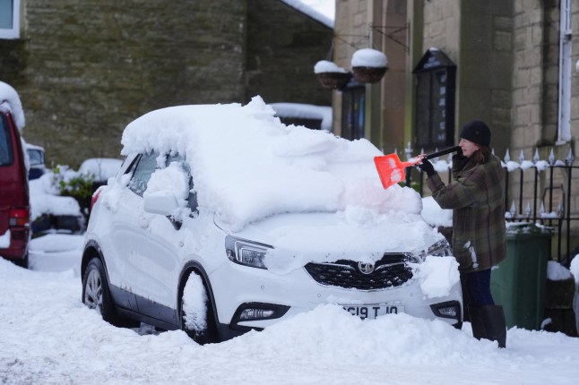 A person clears snow from a car in Allendale, Northumberland. Weather warnings remain in force across much of the UK on Monday with adverse conditions, including flooding from heavy rain and thawing snow. Picture date: Monday January 6, 2025. PA Photo. Photo credit should read: Owen Humphreys/PA Wire