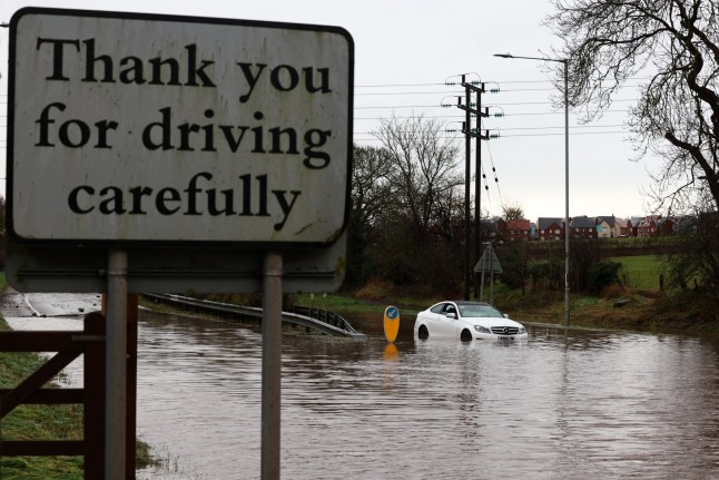 An car is pictured stuck in water on a flooded road, following torrential rain, in Hathern, central England, on January 6, 2025. (Photo by Darren Staples / AFP) (Photo by DARREN STAPLES/AFP via Getty Images)