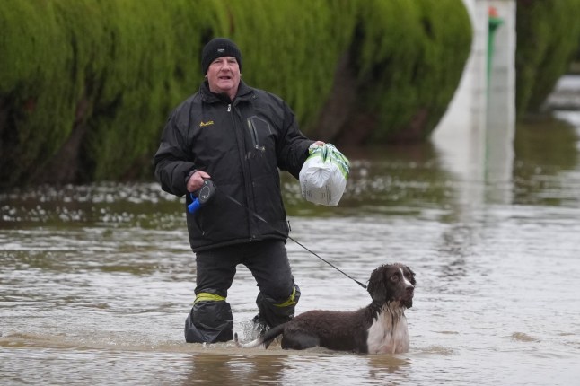 A man and dog walk through flood water at the Little Venice caravan park in Yalding Kent. Weather warnings remain in force across much of the UK on Monday with adverse conditions, including flooding from heavy rain and thawing snow. Picture date: Monday January 6, 2025. PA Photo. Photo credit should read: Gareth Fuller/PA Wire