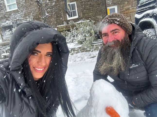 The Tan Hill Inn manager, Nicole, shows Australian guest Paul Wright how to build a snowman at Britain?s highest pub. Release date January 6 2025. More than 30 people are currently snowed in at Britain's highest pub after an Arctic blast swept across the UK. Customers who had trekked to Tan Hill Inn in North Yorkshire - which is is 528 metres (1,732 ft) above sea level - were today (Mon) still holed up in the world famous boozer. Despite amber warnings of snow, 32 guests attended the pub on Saturday night and have remained cut off ever since, along with six staff who were on duty. It comes as temperatures fell to -11.1C in some parts and the Met Office and UK Health Security Agency issued amber "danger to life" alerts ahead of the blizzards.