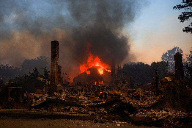 Fire engulfs a building as powerful winds fueling devastating wildfires in the Los Angeles area force people to evacuate, in the Pacific Palisades neighborhood of west Los Angeles, California, U.S. January 8, 2025. REUTERS/Mike Blake