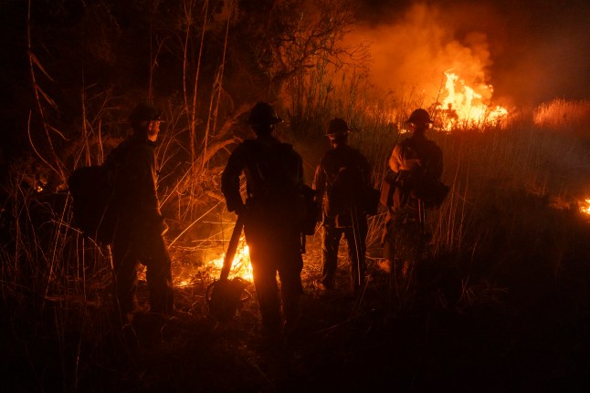 Firefighters monitor and control the spread of the Auto Fire in Oxnard, North West of Los Angeles, California, on January 13, 2025. US officials warned "dangerous and strong" winds were set to push deadly wildfires further through Los Angeles residential areas January 12 as firefighters struggled to make progress against the flames. At least 24 people have been confirmed dead from blazes that have ripped through the city, reducing whole neighborhoods to ashes and leaving thousands without homes. (Photo by ETIENNE LAURENT / AFP) (Photo by ETIENNE LAURENT/AFP via Getty Images)