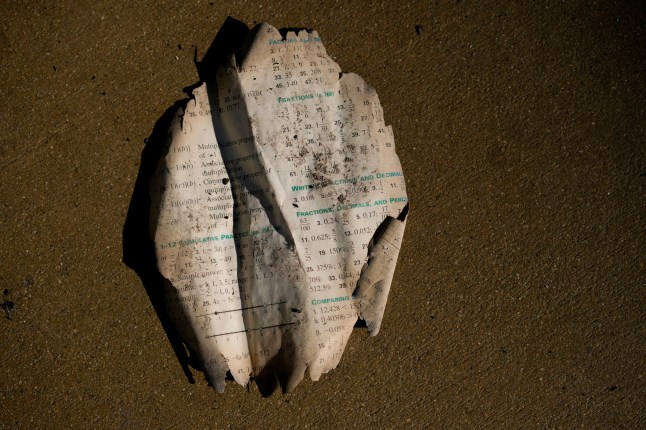 A burned text book is left behind at Palisades High School in the aftermath of the Palisades Fire in the Pacific Palisades neighborhood of Los Angeles, Tuesday, Jan. 14, 2025. (AP Photo/Carolyn Kaster)