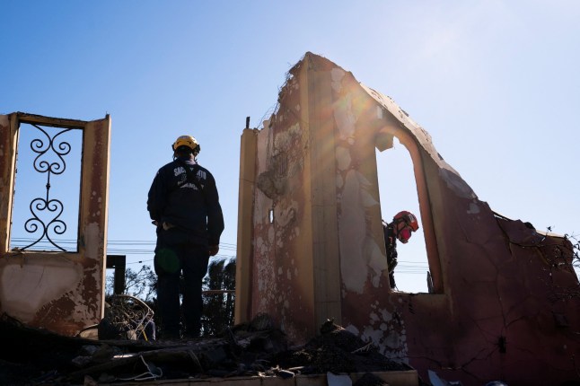 A search and rescue team searches the remains of a home burned by the Palisades Fire, in the Pacific Palisades neighborhood in Los Angeles, California, U.S. January 14, 2025. REUTERS/David Ryder