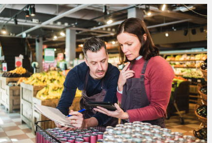 Two retail employees working together in the produce section