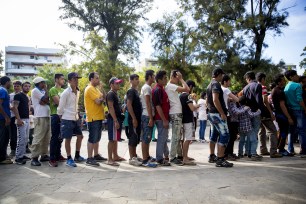 Refugees line up to receive food in a park near the port of Mytilini on Sept. 9 in Lesbos, Greece.