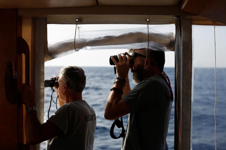 Open Arms captain Riccardo Gatti, right, and a volunteer search for migrants in the Mediterranean Sea.