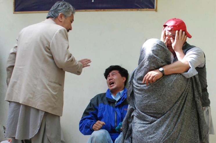 Family members of the blast comfort each other outside a mortuary.