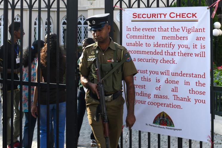 A Sri Lankan police officer stands guard at the main entrance of the St. Theresa's church as the Catholic churches hold services again after the Easter attacks in Colombo.